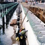 Workers Examining Side of Pier Installation